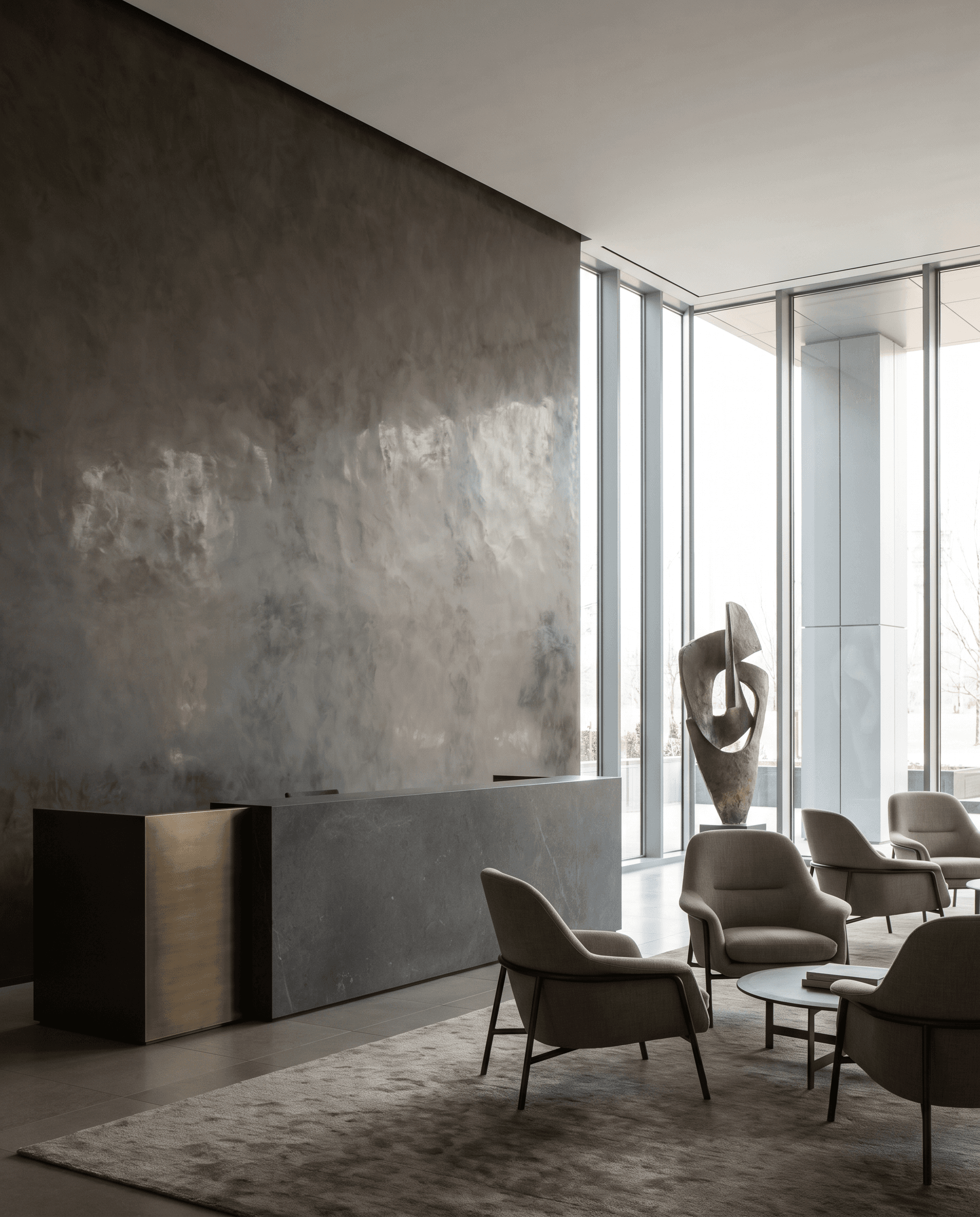 Modern corporate office reception with a hand-troweled polished Venetian plaster feature wall in warm charcoal-greige